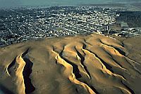 Ørkensand, der kryber mod en by